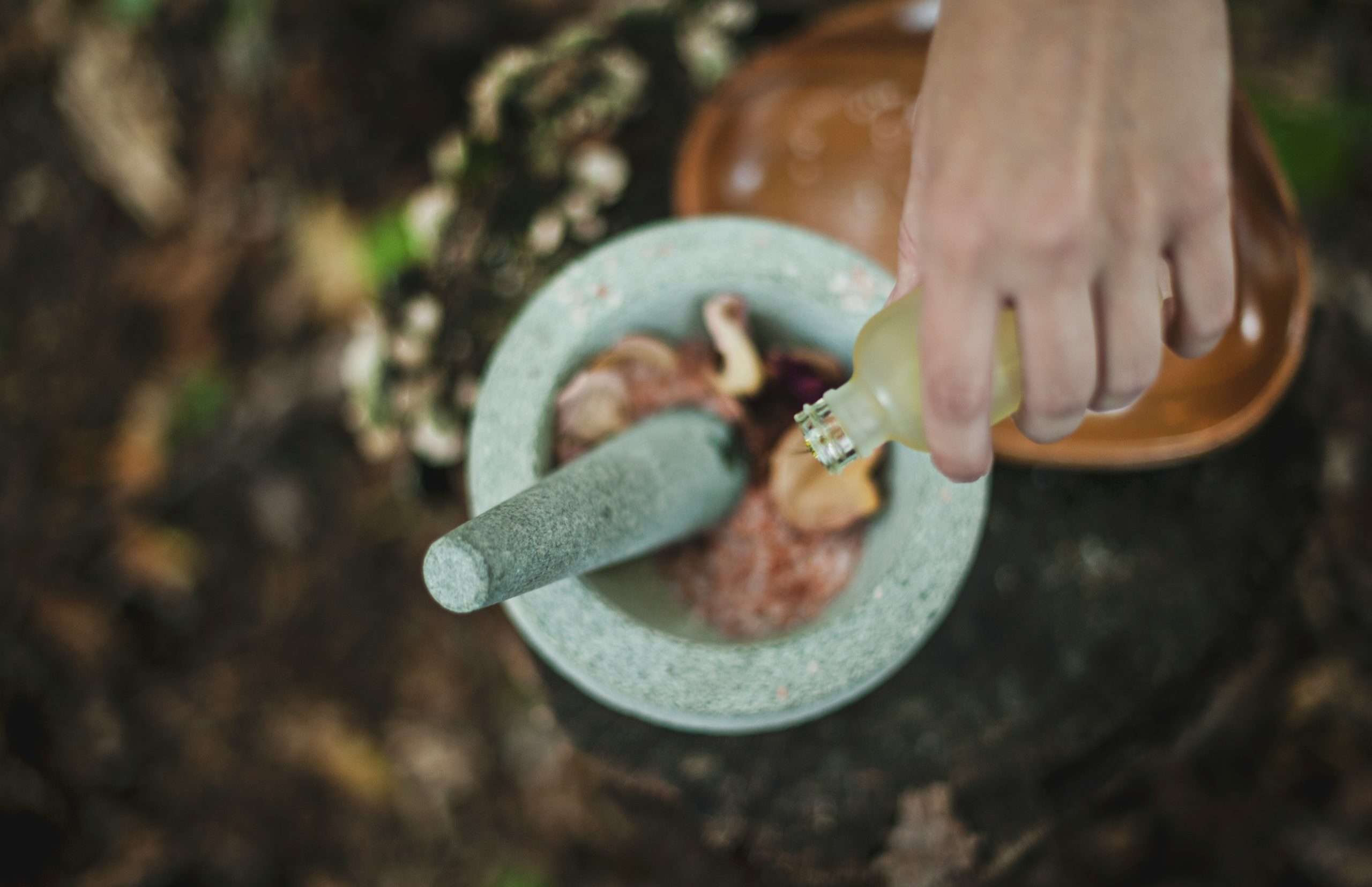 Artisan(e) moulant des fleurs et ajoutant des huiles essentielles pour créer des produits naturels et faits main